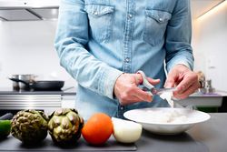 Man chopping seafood with scissors