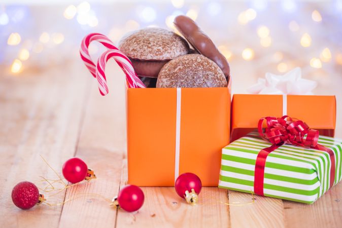 Gift with sweets and baubles on wood table