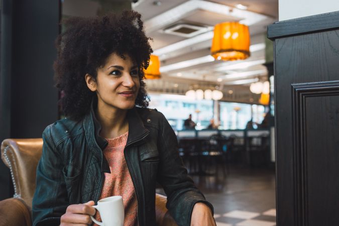 Black woman with afro hair drinking a coffee