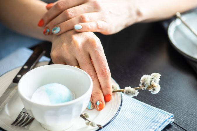 Hands of woman with pussy willow from Easter table setting