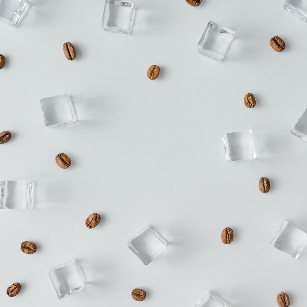 Coffee beans and ice cubes pattern on bright background
