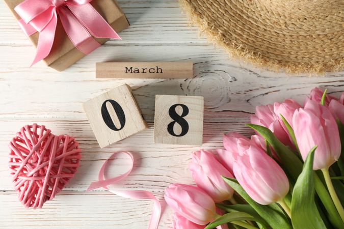 Composition with wood calendar and tulips on wooden background, top view