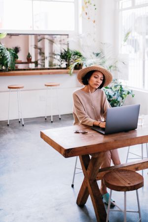 Young woman sitting in a coffee shop while using a laptop