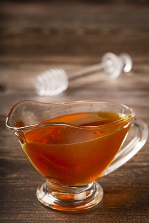 Honey in glass bowl on the table.
