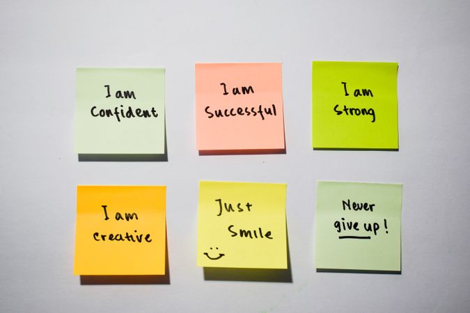I am confident, I am strong, never give up with smile emoticon on sticky notes