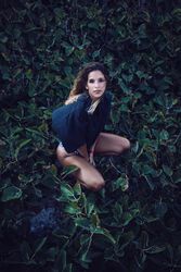 Tranquil woman in stylish clothing delighting in forest