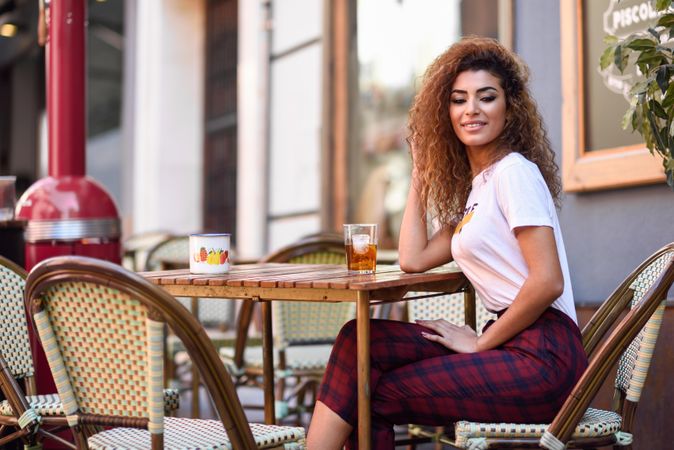 Arab woman in casual clothes drinking a soda outdoors