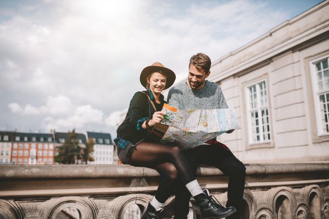 Young tourist couple exploring the navigation map of a city