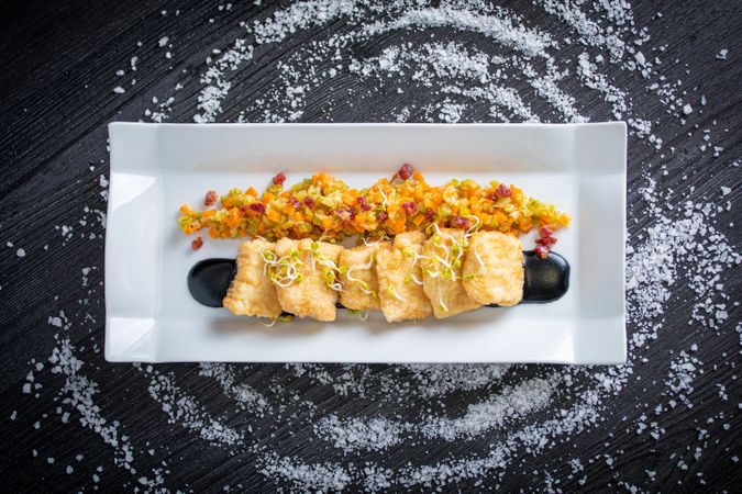 Hake breaded with matignon in rectangular plate