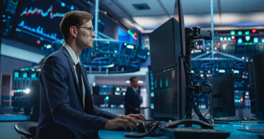 Portrait of a Stock Exchange Broker Working on Computer, Researching Real-Time Stocks Data, Analyzing Commodities and Exchange Market Charts.