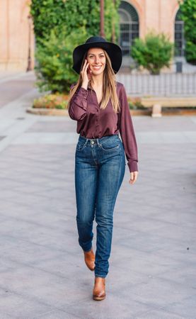 Woman in trendy outfit talking on smartphone