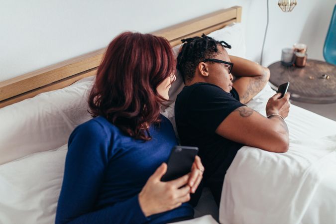 Man and woman in bed with cellphones