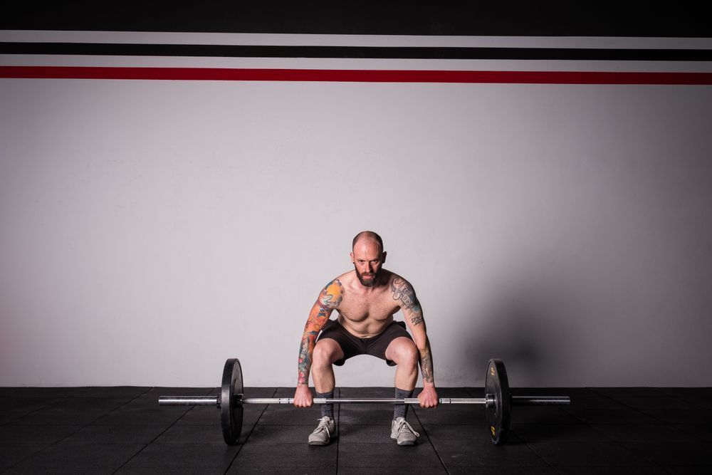 Man lifting barbell in gym