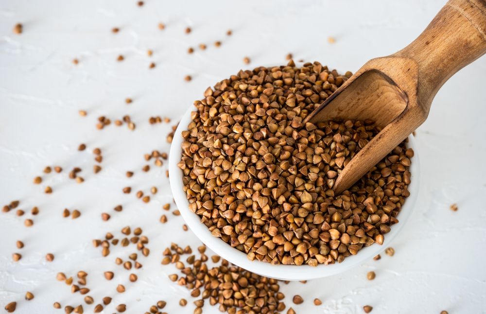 Top view of organic raw buckwheat seeds in a bowl on table 