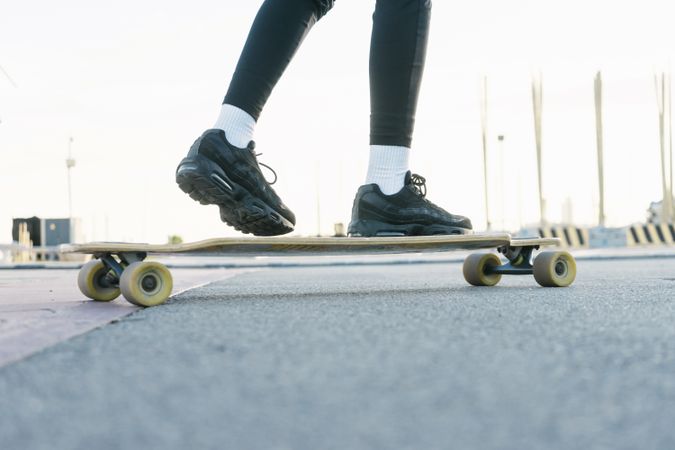 Feet of woman riding on longboard on the street