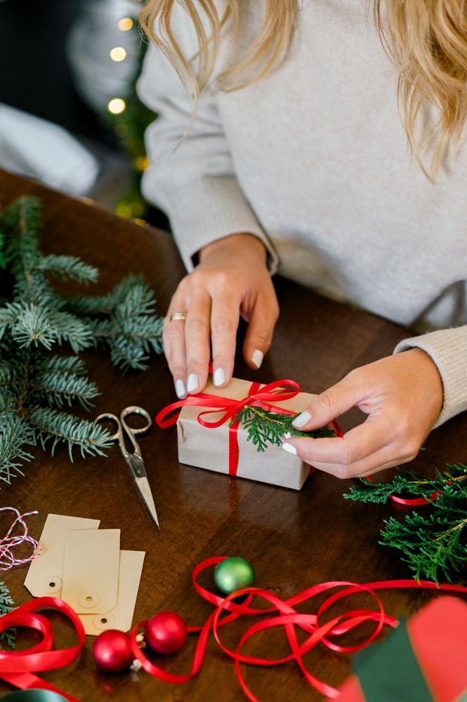 Woman making beautiful Christmas gift at table