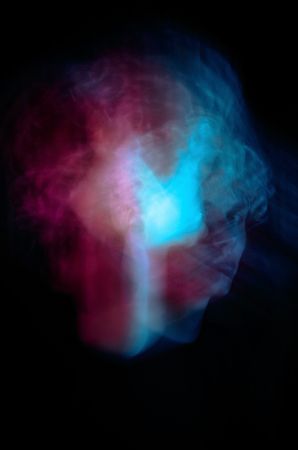 Long exposure of moving face against dark background