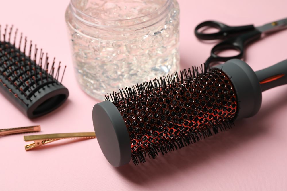 Composition with hairdresser accessories on pink background, close up