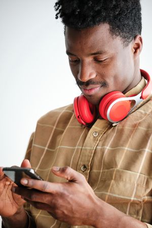 Black man with headphones surfing internet on smartphone