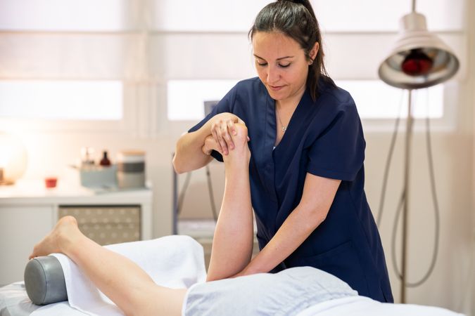 Medical massage on leg on massage table