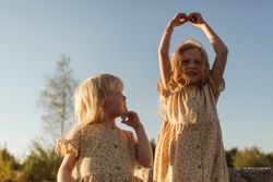 Happy sisters enjoying summer evening in countryside