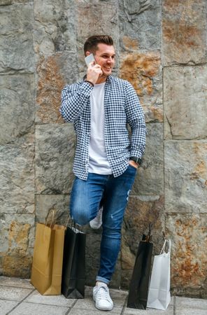 Young man with shopping bags and mobile
