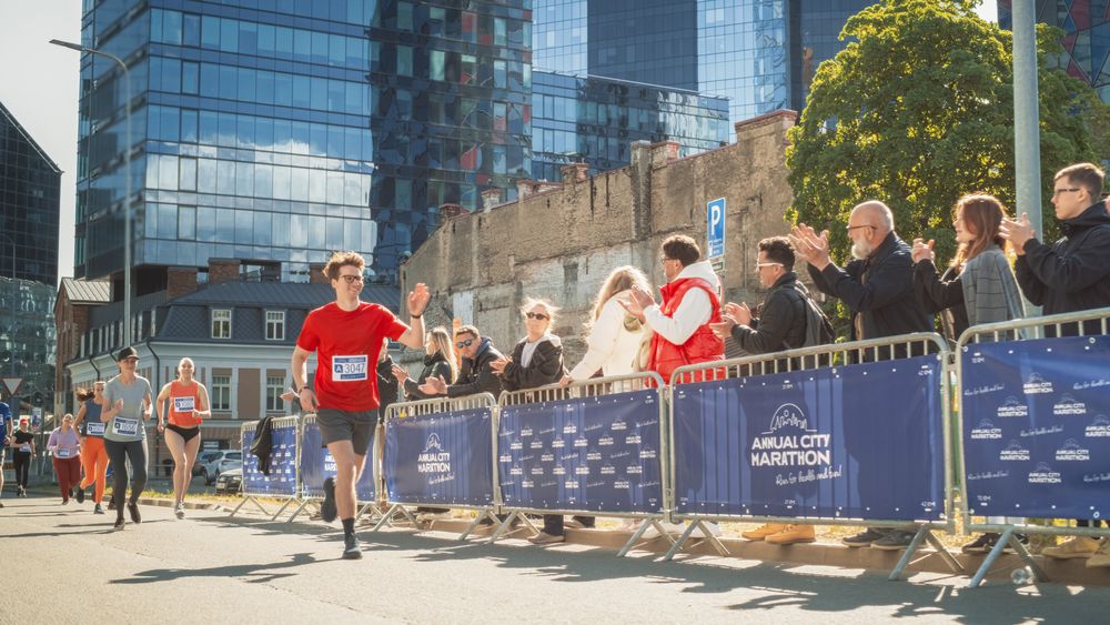 Diverse People Running in a Marathon and Waving to their Loved Ones and Supporters in the Audience.