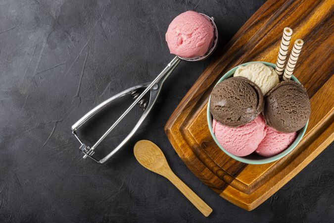 Bowl with Neapolitan ice cream on dark background.