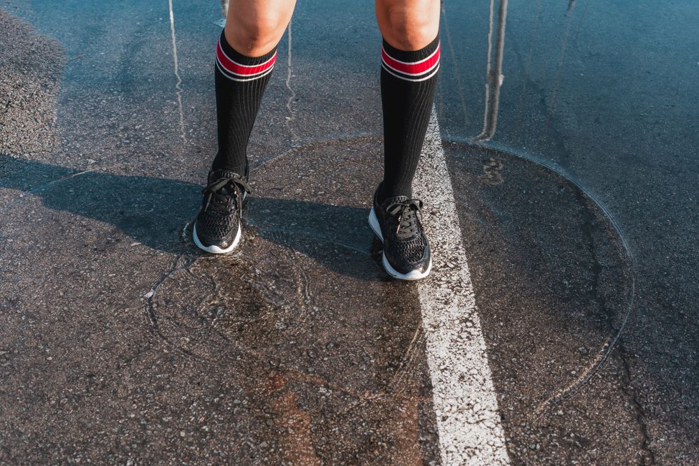 Woman in knee socks and shoes standing in puddles