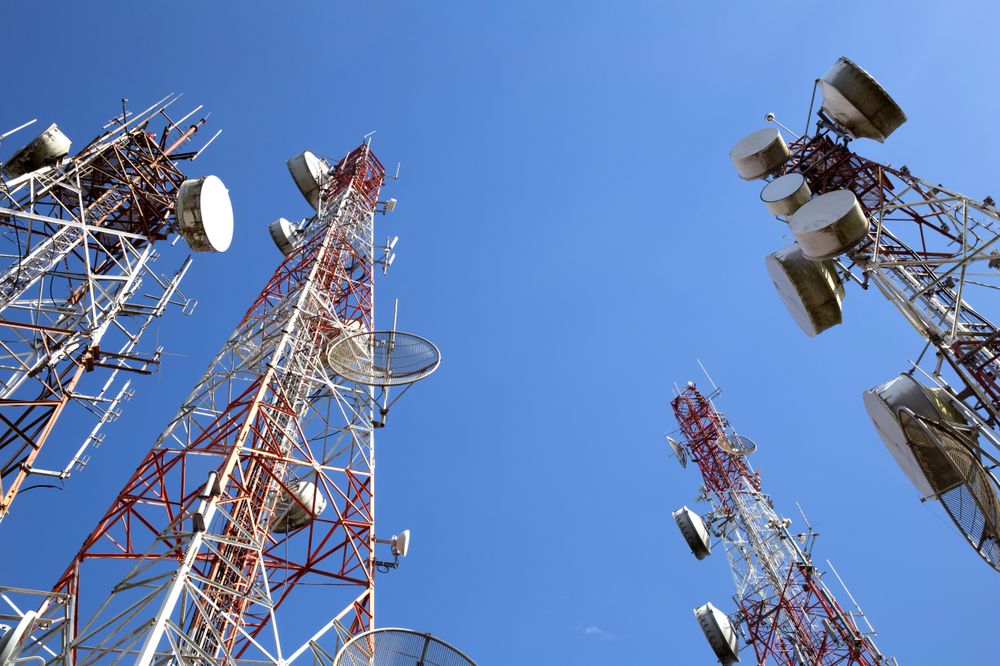 Tall Telecommunication Towers Against a Clear Blue Sky