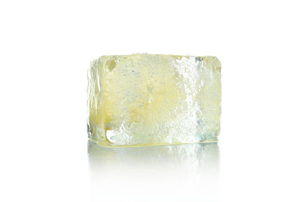 Single clear ice cube with lemon slice