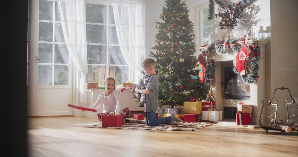 Cute Children Impatient to Get Their Gifts from Under the Christmas Tree at Home.