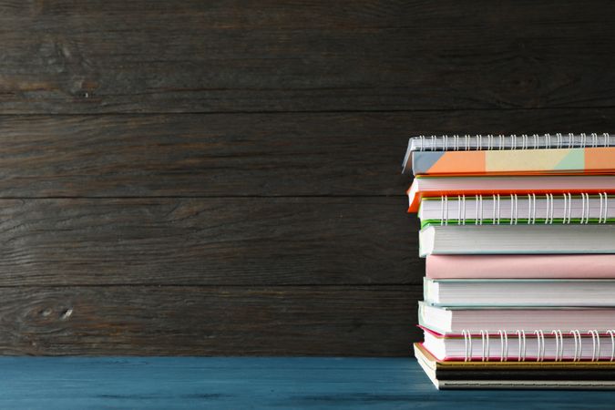 Composition with copybooks on wood table against dark background