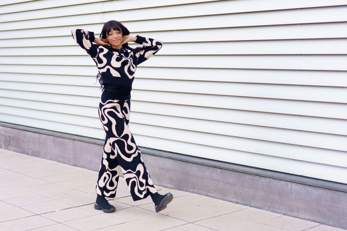Woman in modern clothes walking along the street gesturing vitality