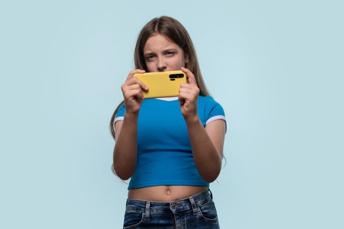 Girl concentrating intensely while holding smartphone