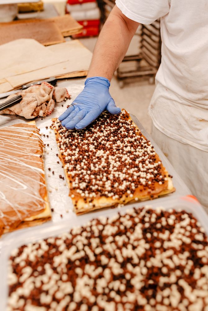 Anonymous baker spreading sprinkles on pastry
