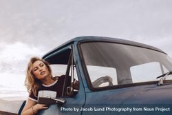 Woman traveling by a old truck on road trip 5RmJ20
