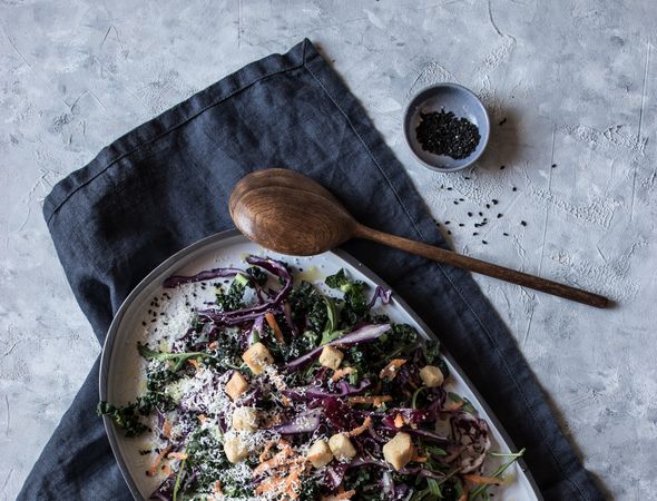 Poppy seeds and lemon near vegetable salad with croutons and parmesan
