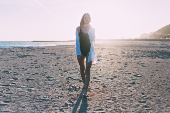 Woman standing relaxing on beach at sunset