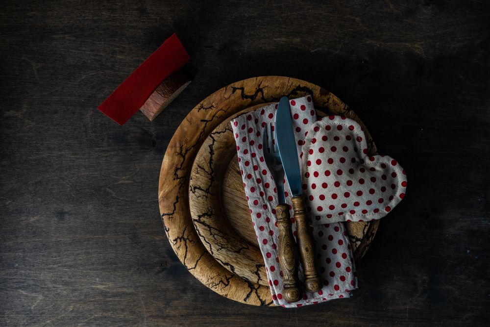 Valentine's day table setting with red dotted napkin and heart decoration on rustic plate