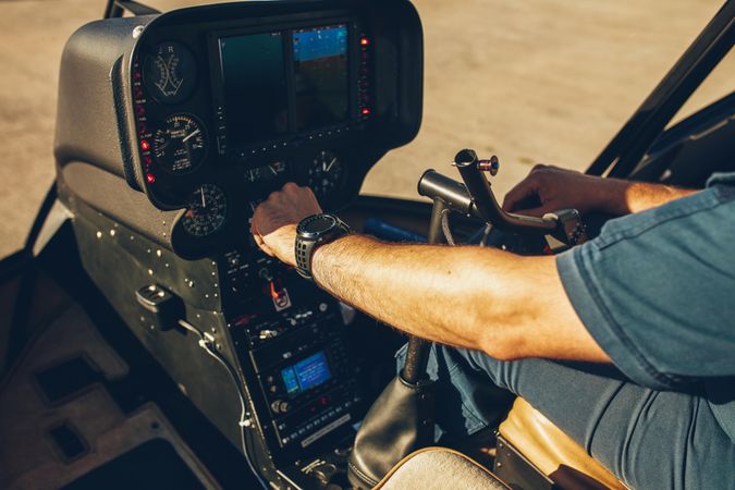 Pilot's hand on an helicopter instrument panel
