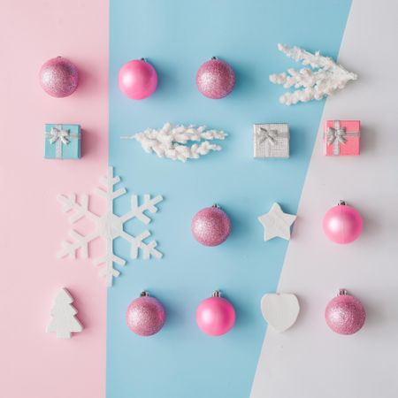 Pink, blue and light-colored Christmas decorations on pastel pink and blue background