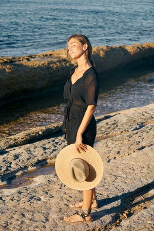 Calm woman enjoying sun on beach