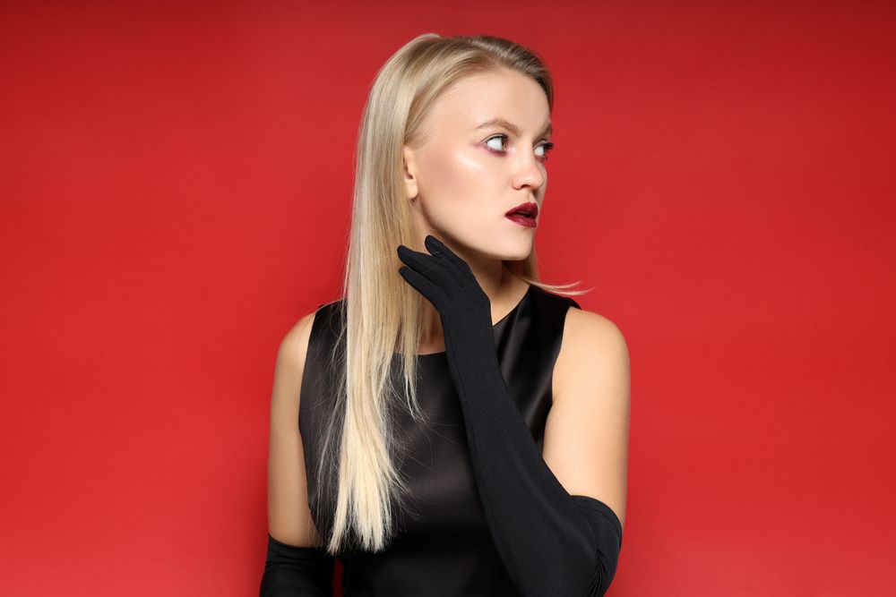 Concept of Halloween, young woman on red background