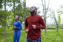 Two friends preparing with warm-up exercises before their workout.
