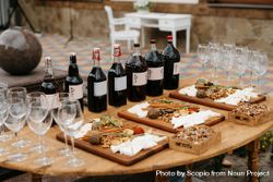 Wine bottles and variation of aged cheese on brown wooden table bDmGy0
