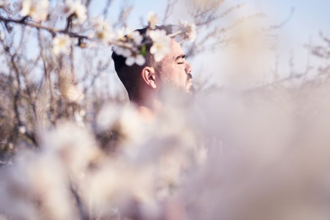 Shirtless man meditating in spring garden