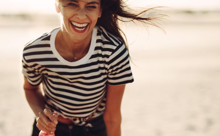 Woman laughing and having fun on the beach in the summer