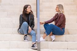 Smiling women talking on street staircase