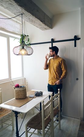 Man drinking hot tea during knitting